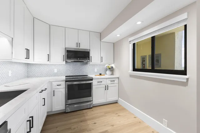 a kitchen with a refrigerator sink and white cabinets