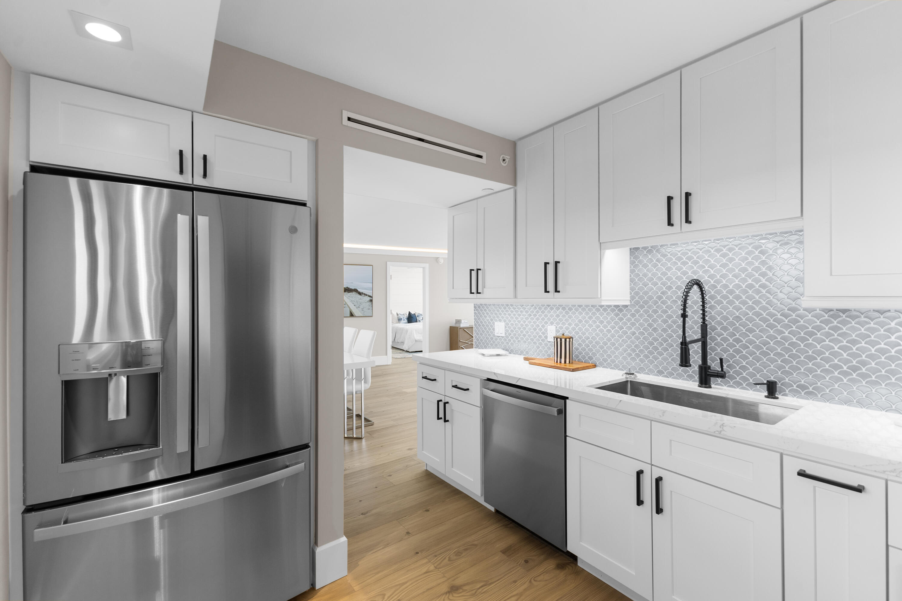 400 Ocean Trail Way, Unit 1008 Jupiter, FL 33477 - Photo 6 of 32 a kitchen with a refrigerator sink and white cabinets