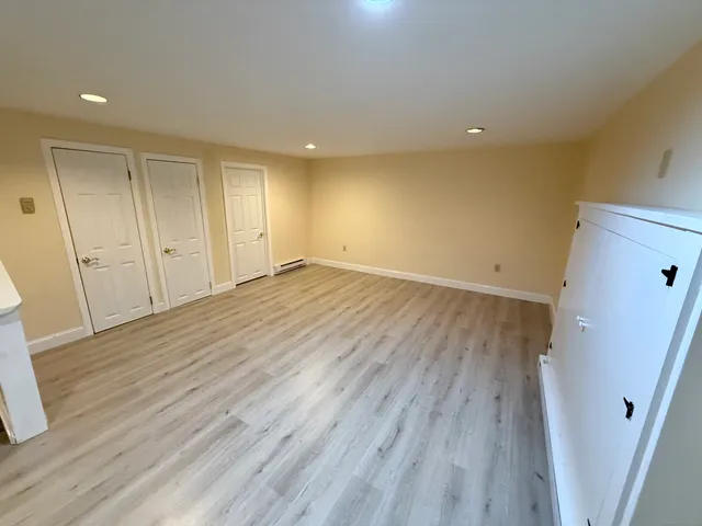 a view of an empty room with wooden floor and staircase