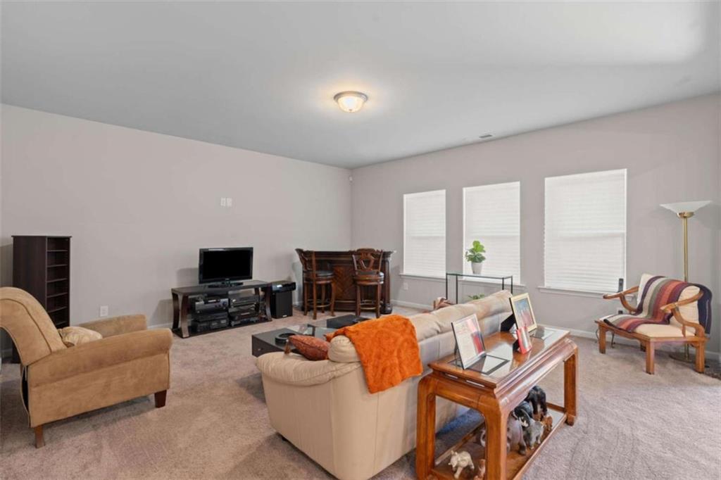 9068 Jim Purcell Drive Covington, GA 30014 - Photo 13 of 48 a living room with furniture a fireplace and a flat screen tv