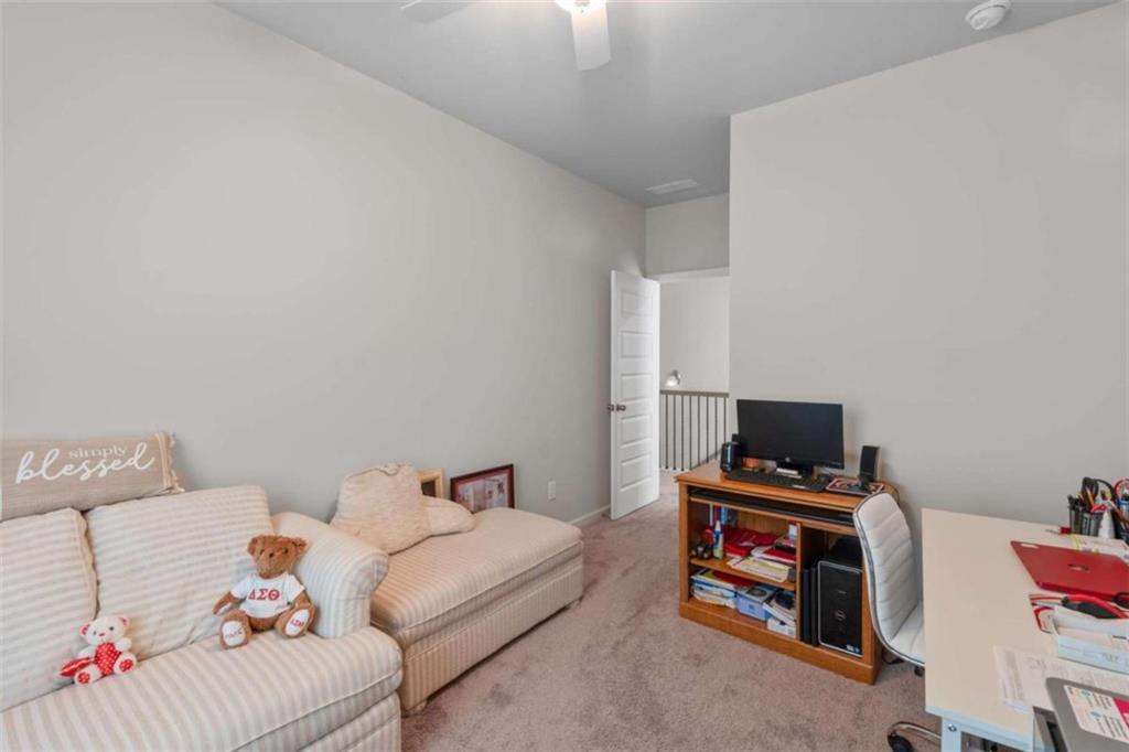 9068 Jim Purcell Drive Covington, GA 30014 - Photo 32 of 48 a living room with furniture and a flat screen tv