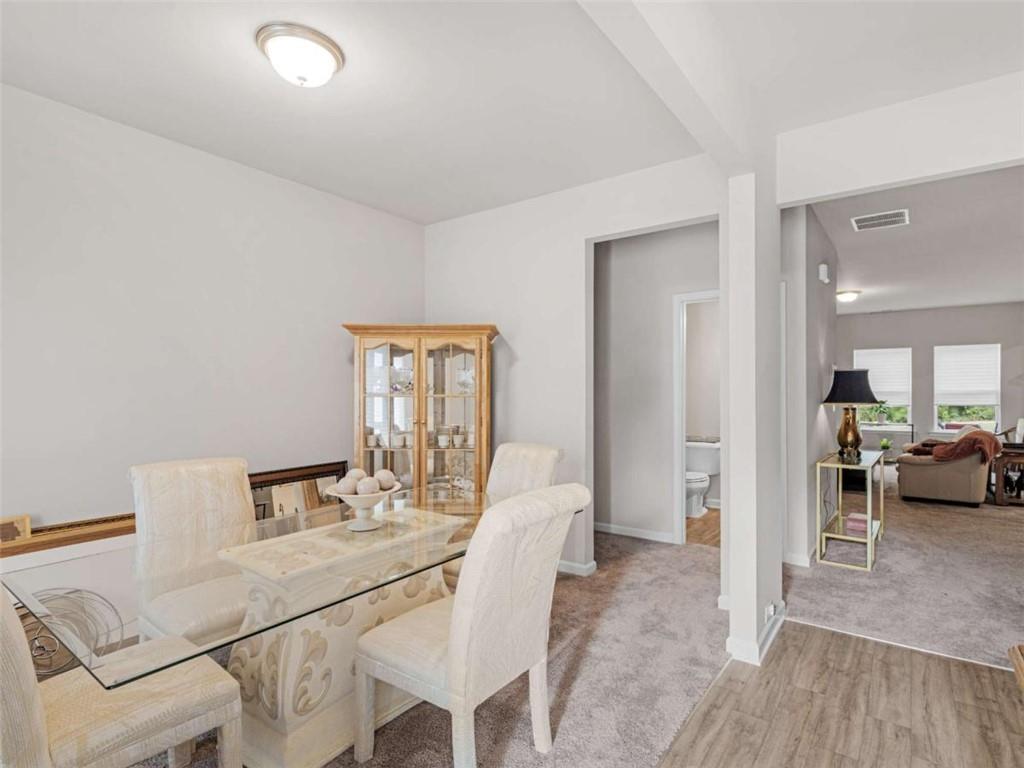 9068 Jim Purcell Drive Covington, GA 30014 - Photo 7 of 48 a view of a dining room with furniture and a wooden floor