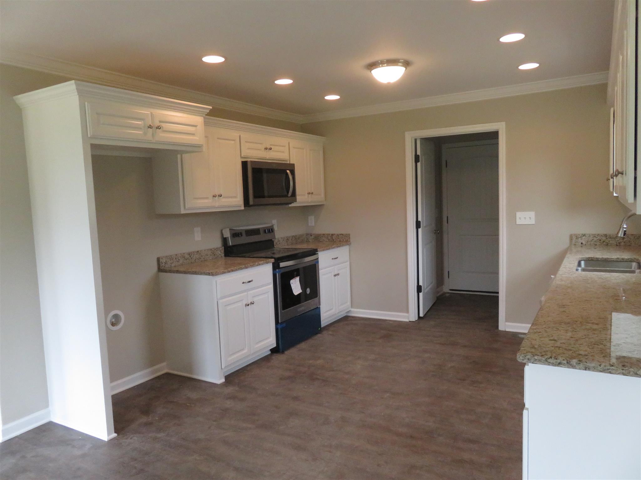 51 Shipley Road Manchester, TN 37355 - Photo 6 of 13 Kitchen with white cabinets, stainless steel appliances and HW flooring.