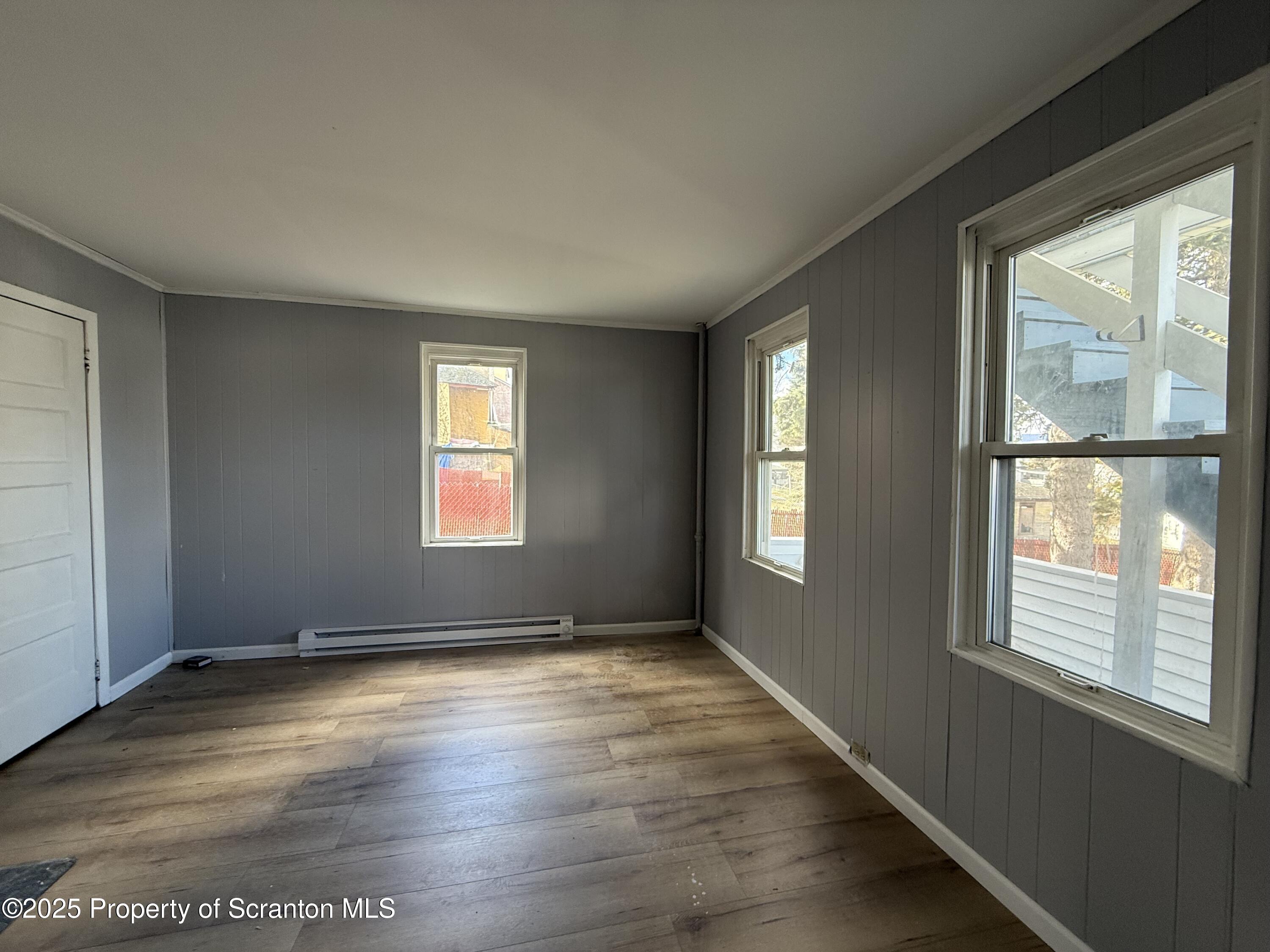 1706 Prospect Avenue, Unit REAR Scranton, PA 18505 - Photo 13 of 18 an empty room with wooden floor and windows