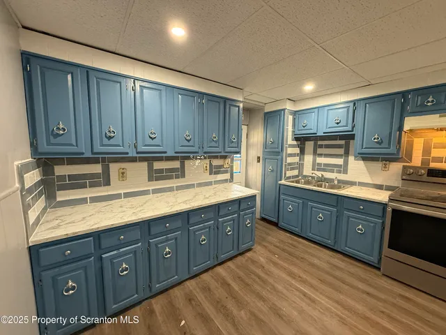 a kitchen with stainless steel appliances granite countertop a sink a stove and cabinets