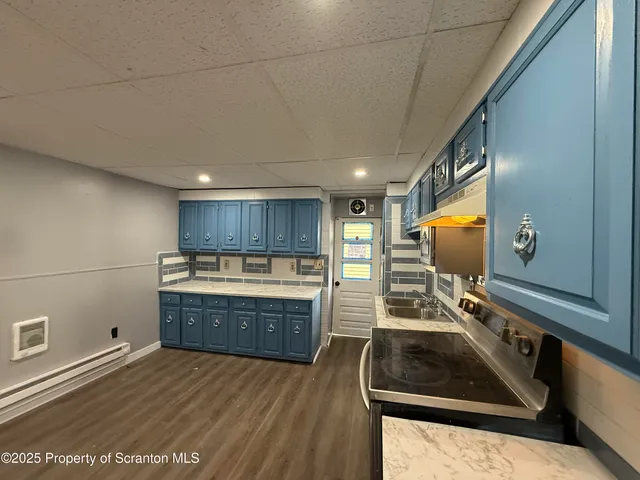 a kitchen with sink a stove and cabinets