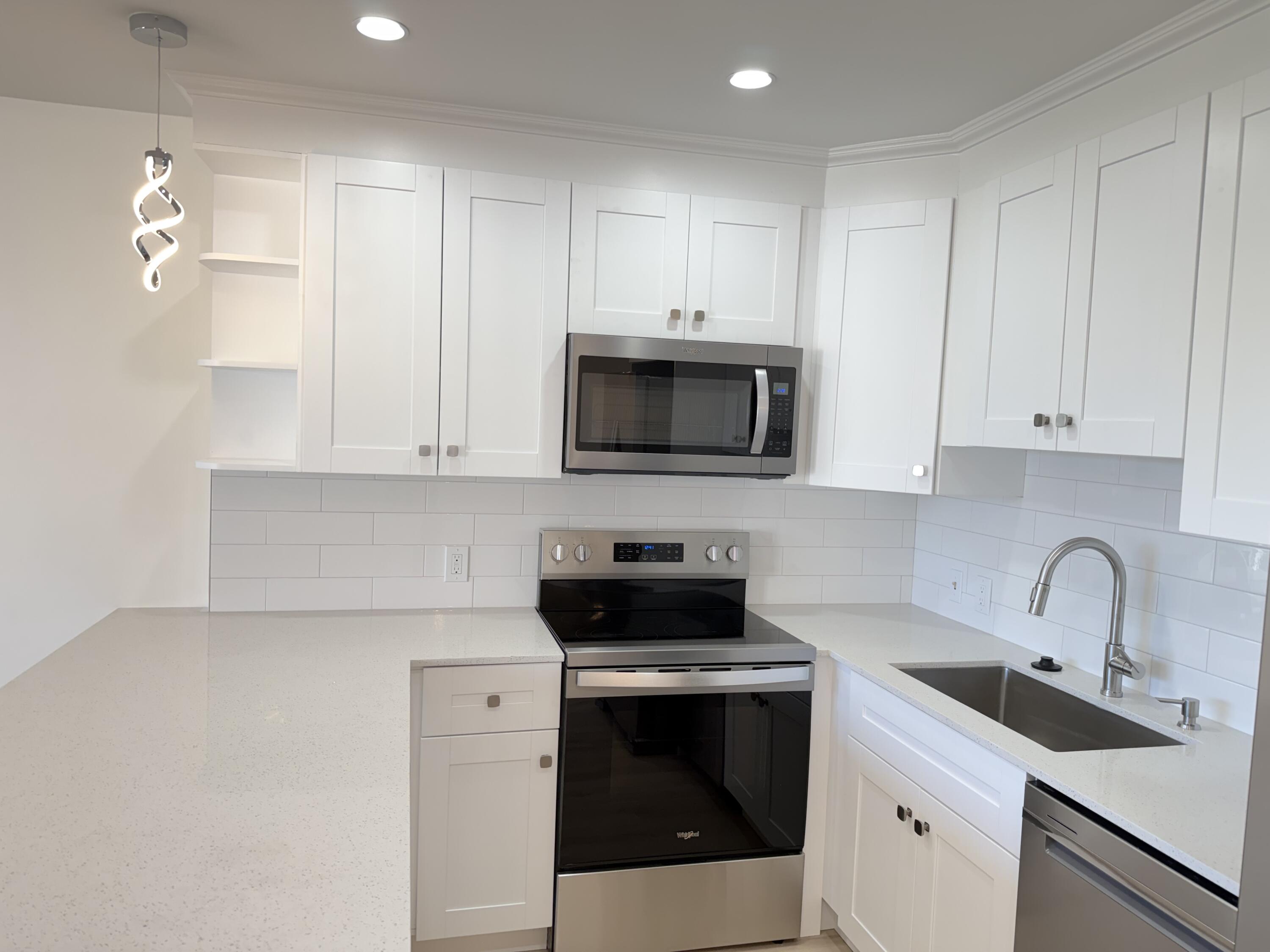 37 Suffolk Way Boca Raton, FL 33434 - Photo 3 of 40 a kitchen with white cabinets and stainless steel appliances