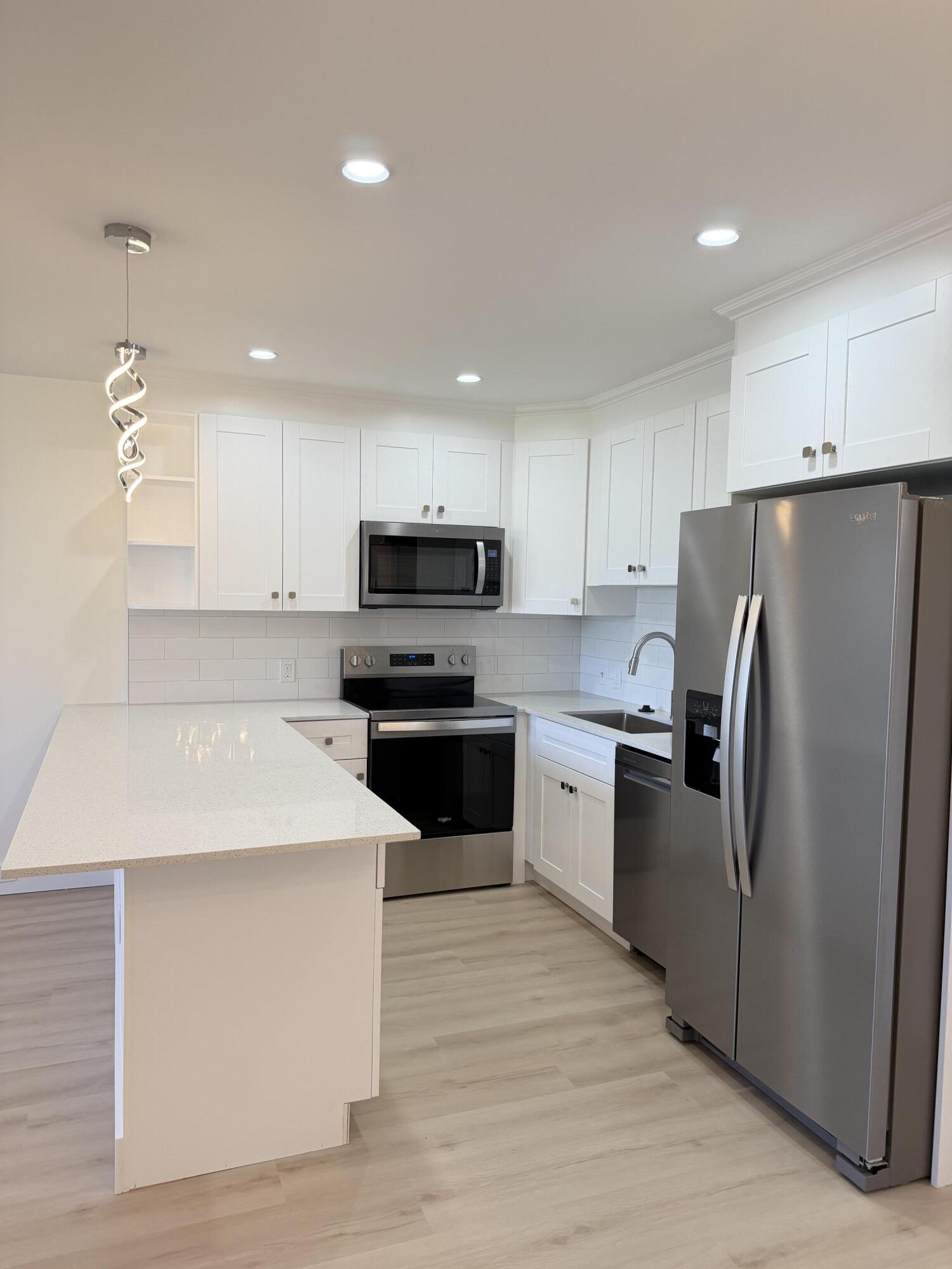 37 Suffolk Way Boca Raton, FL 33434 - Photo 36 of 40 a kitchen with wooden cabinets and stainless steel appliances