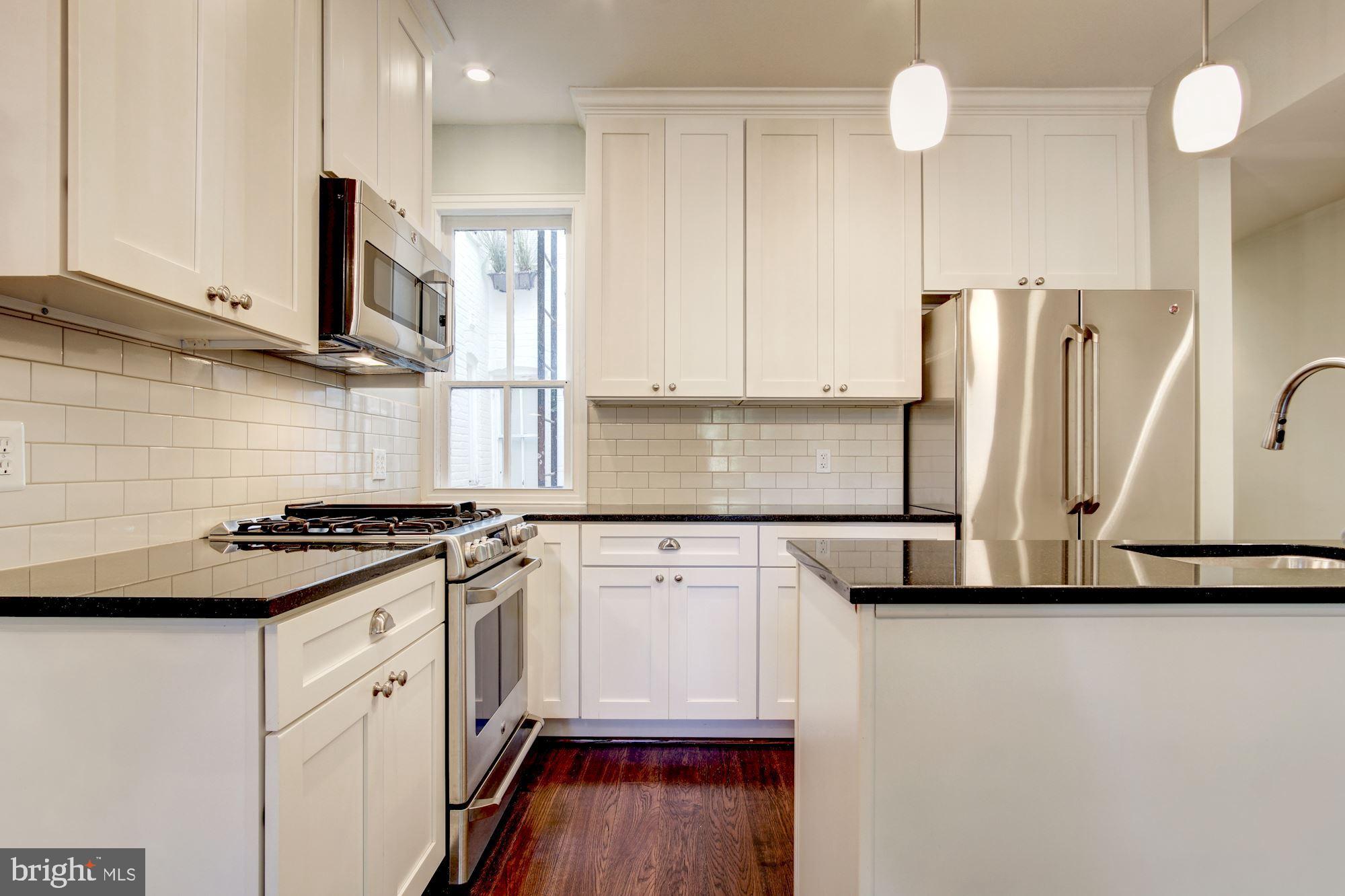 3040 R Street Northwest, Unit 1/2 Washington, DC 20007 - Photo 18 of 33 a kitchen with stainless steel appliances granite countertop a stove a sink and a refrigerator