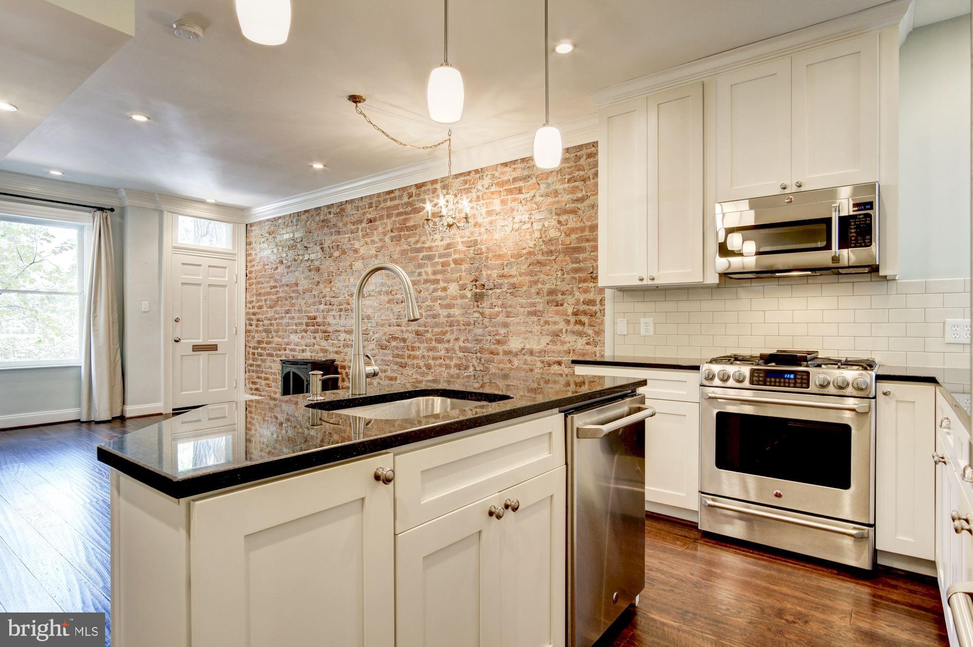 3040 R Street Northwest, Unit 1/2 Washington, DC 20007 - Photo 8 of 33 a kitchen with stainless steel appliances granite countertop a sink a stove and a microwave