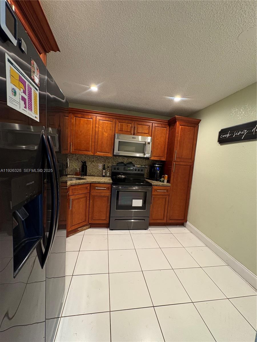 3350 Northwest 47th Avenue, Unit 3273 Coconut Creek, FL 33063 - Photo 11 of 11 a kitchen with stainless steel appliances granite countertop a stove a sink and a microwave