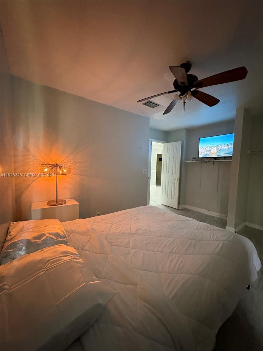 3350 Northwest 47th Avenue, Unit 3273 Coconut Creek, FL 33063 - Photo 5 of 11 a bedroom with a bed and a chandelier