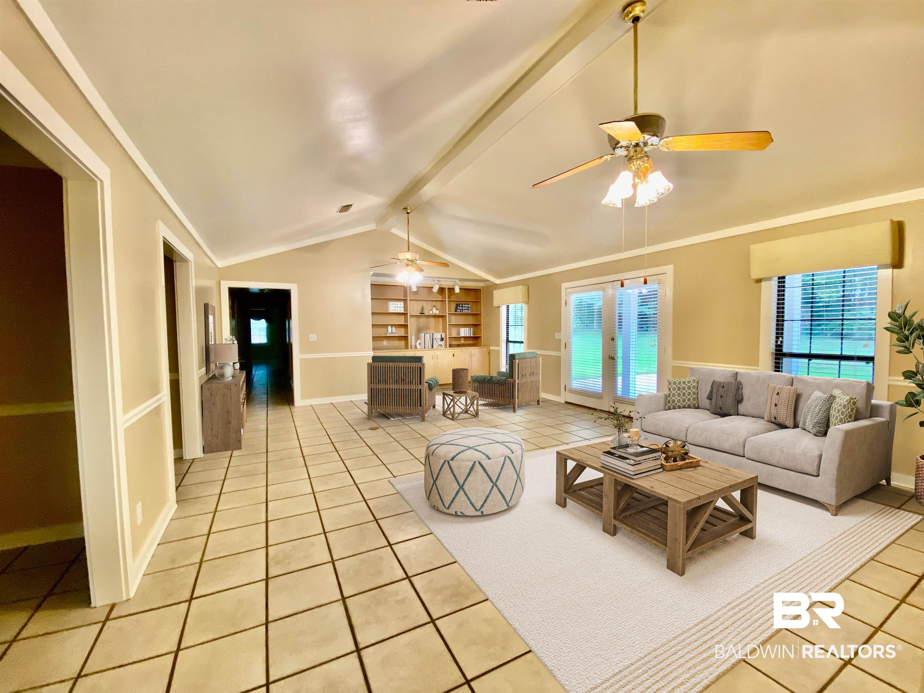 160 Mockingbird Lane Monroeville, AL 36460 - Photo 6 of 36 Living area with light tile patterned flooring, a ceiling fan, built in shelves, and crown molding