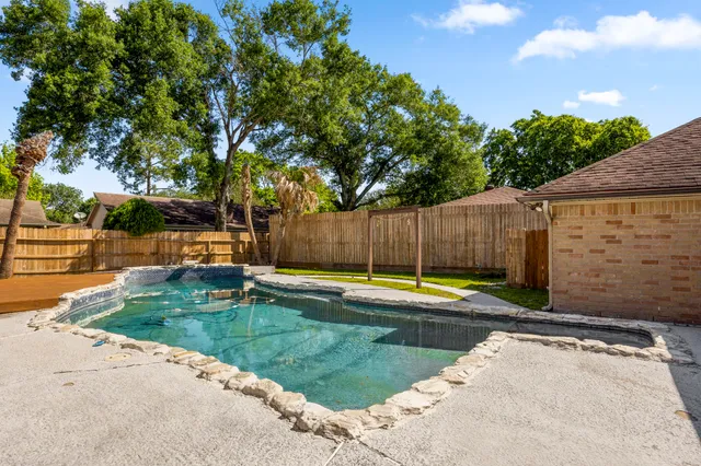 a view of a backyard with swimming pool