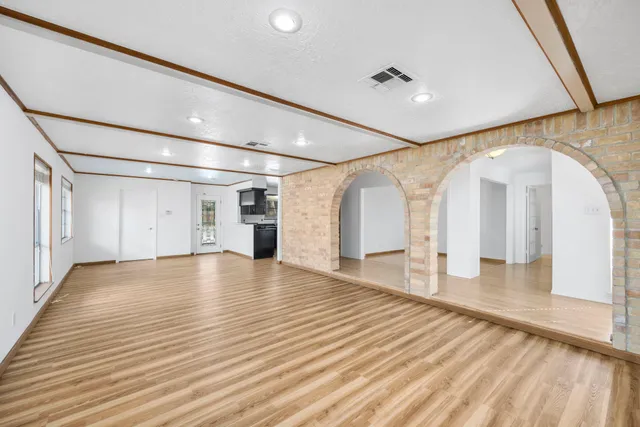 a view of empty room with wooden floor