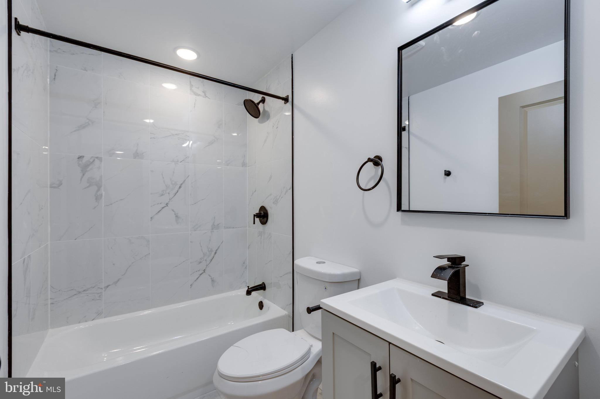 2203 North 7th Street, Unit 2 Philadelphia, PA 19133 - Photo 9 of 12 a bathroom with a sink a toilet a mirror and a glass door shower