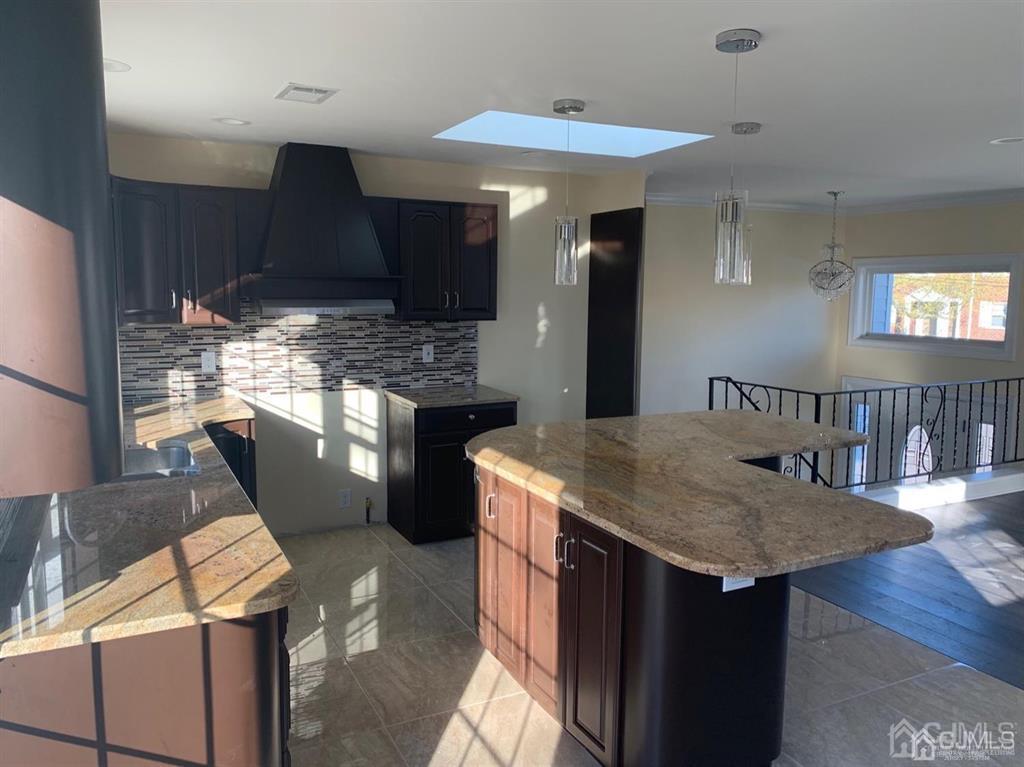 179 Phillips Road Somerset, NJ 08873 - Photo 8 of 26 a kitchen with stainless steel appliances kitchen island granite countertop a table chairs in it and wooden floors