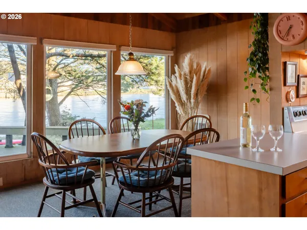 a dining room with furniture a floor to ceiling window and outside view