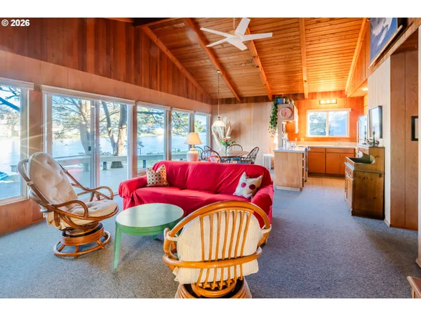 a living room with furniture a large window and dining table