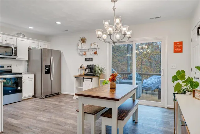 a view of a dining room with furniture a chandelier and wooden floor