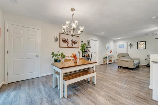 a view of a dining room with furniture a chandelier and wooden floor