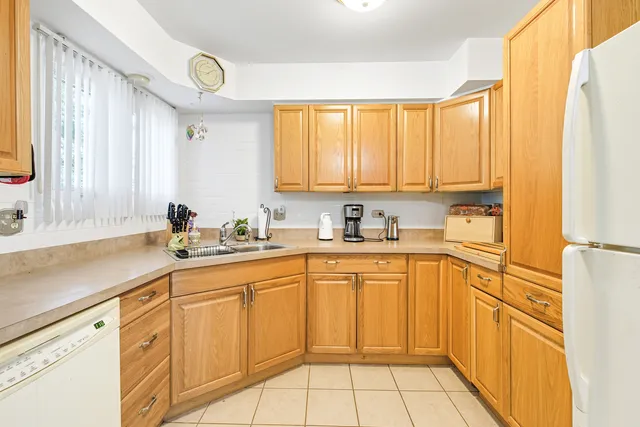 a kitchen with sink refrigerator dining table and chairs