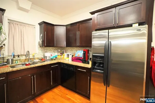 a kitchen with stainless steel appliances granite countertop a refrigerator and a sink