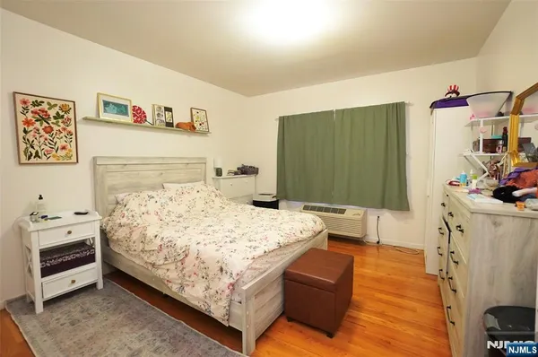 a bedroom with a bed and a flat tv screen on dresser