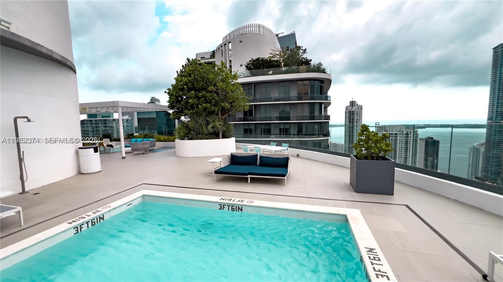 55 Southwest 9th Street, Unit 2305 Miami, FL 33130 - Photo 19 of 23 a swimming pool with outdoor seating and a garden