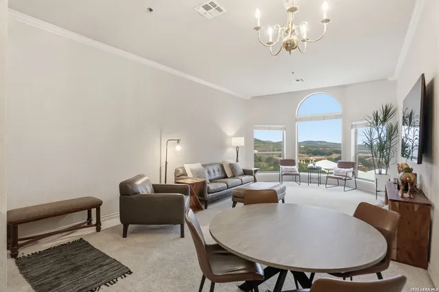 a living room with furniture a chandelier and a dining table