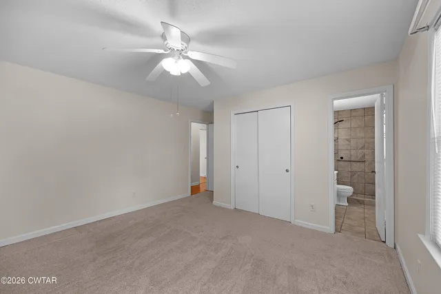 an empty room with closet and a chandelier fan