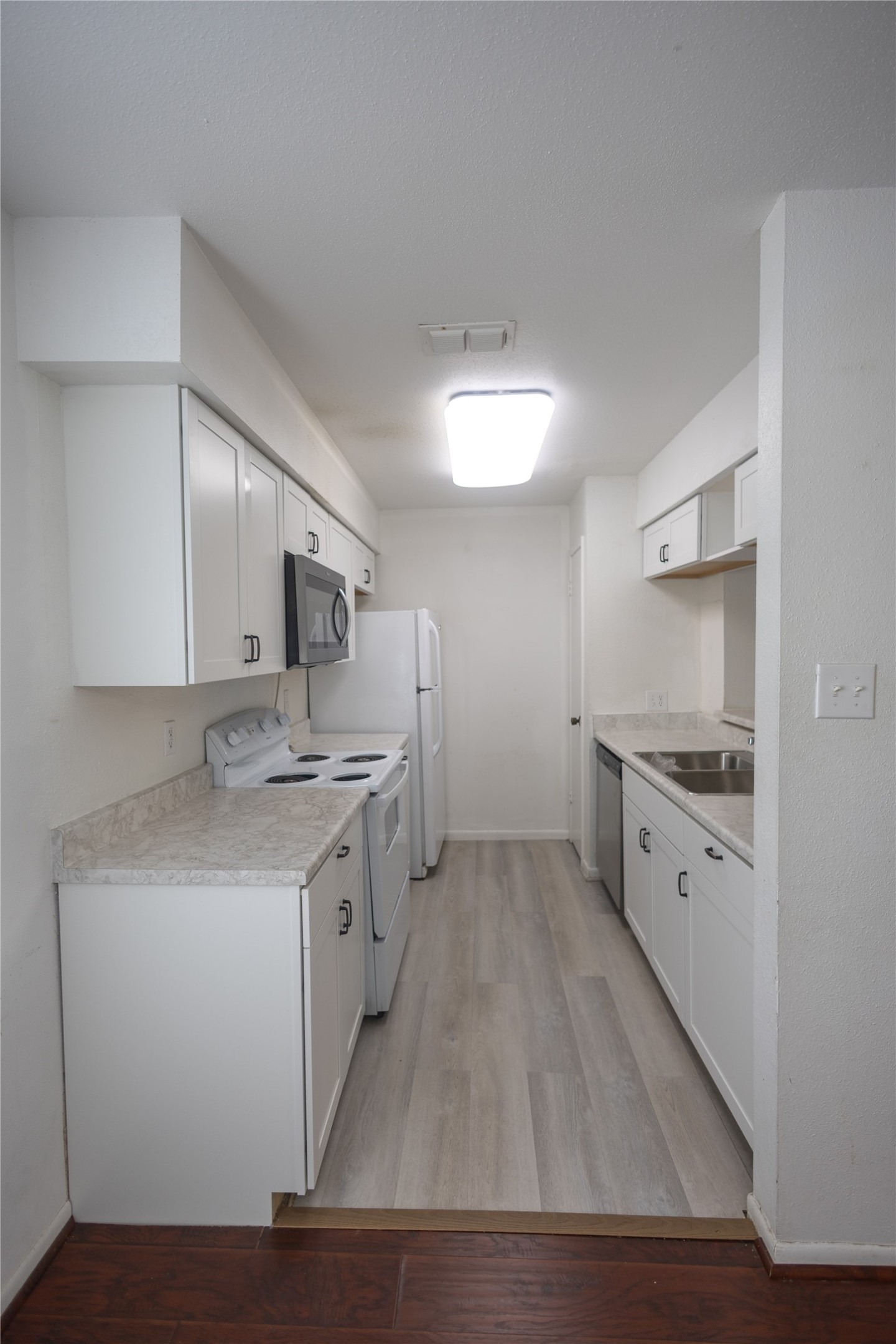 8100 Cambridge Street, Unit 89 Houston, TX 77054 - Photo 11 of 41 Galley-style kitchen with white cabinetry, light countertops, and full appliance package in an efficient layout.