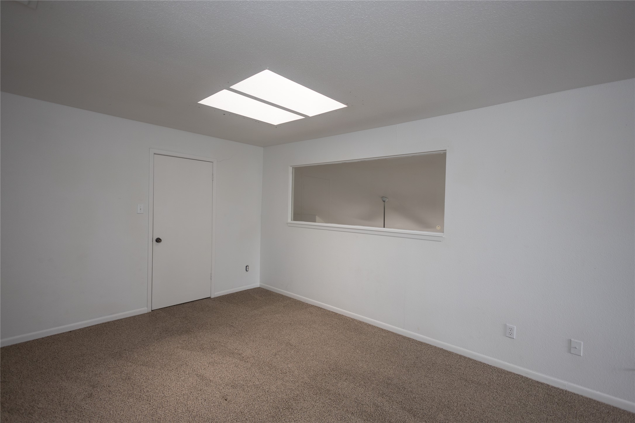 8100 Cambridge Street, Unit 89 Houston, TX 77054 - Photo 28 of 41 Upstairs primary bedroom with skylights, neutral carpet, and an open layout filled with natural light