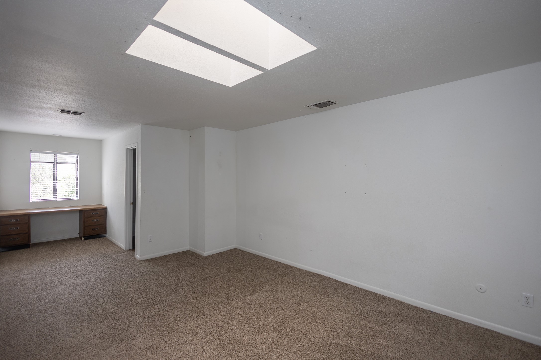 8100 Cambridge Street, Unit 89 Houston, TX 77054 - Photo 30 of 41 Upstairs primary bedroom with neutral carpet, abundant natural light, and a built-in desk for added functionality.