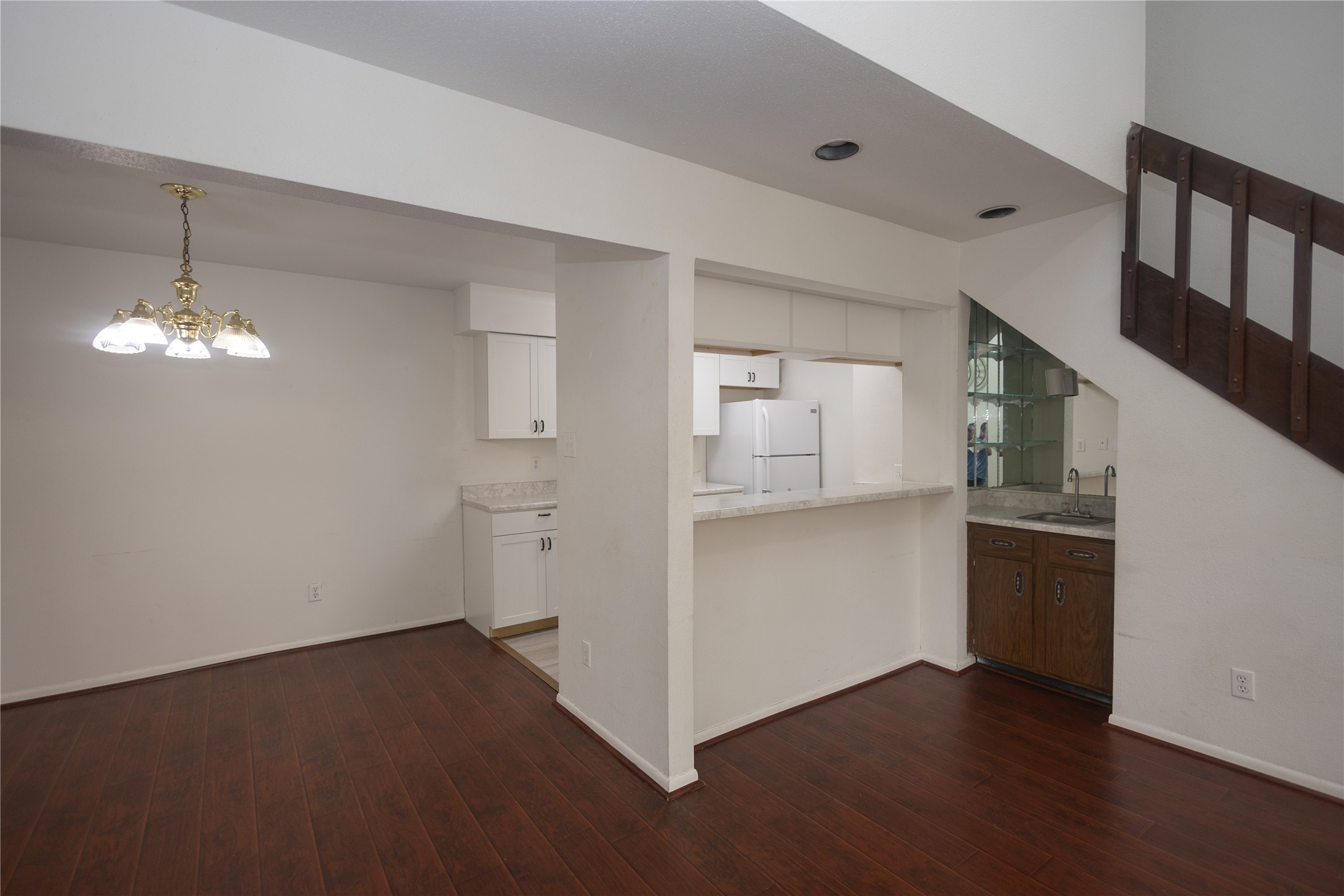8100 Cambridge Street, Unit 89 Houston, TX 77054 - Photo 8 of 41 Open living and dining area with dark wood floors, high ceilings, a breakfast bar, and a staircase leading to the upper level