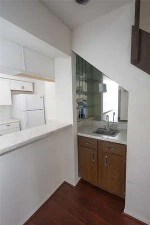a kitchen with a sink cabinets and wooden floor