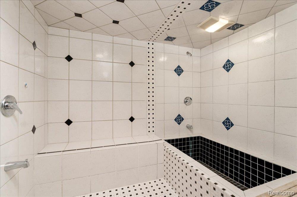 3543 Cedar Brook Drive Rochester, MI 48309 - Photo 59 of 99 Tiled shower enclosure featuring a built-in bench, integrated deep soaking tub, and decorative accent tiles