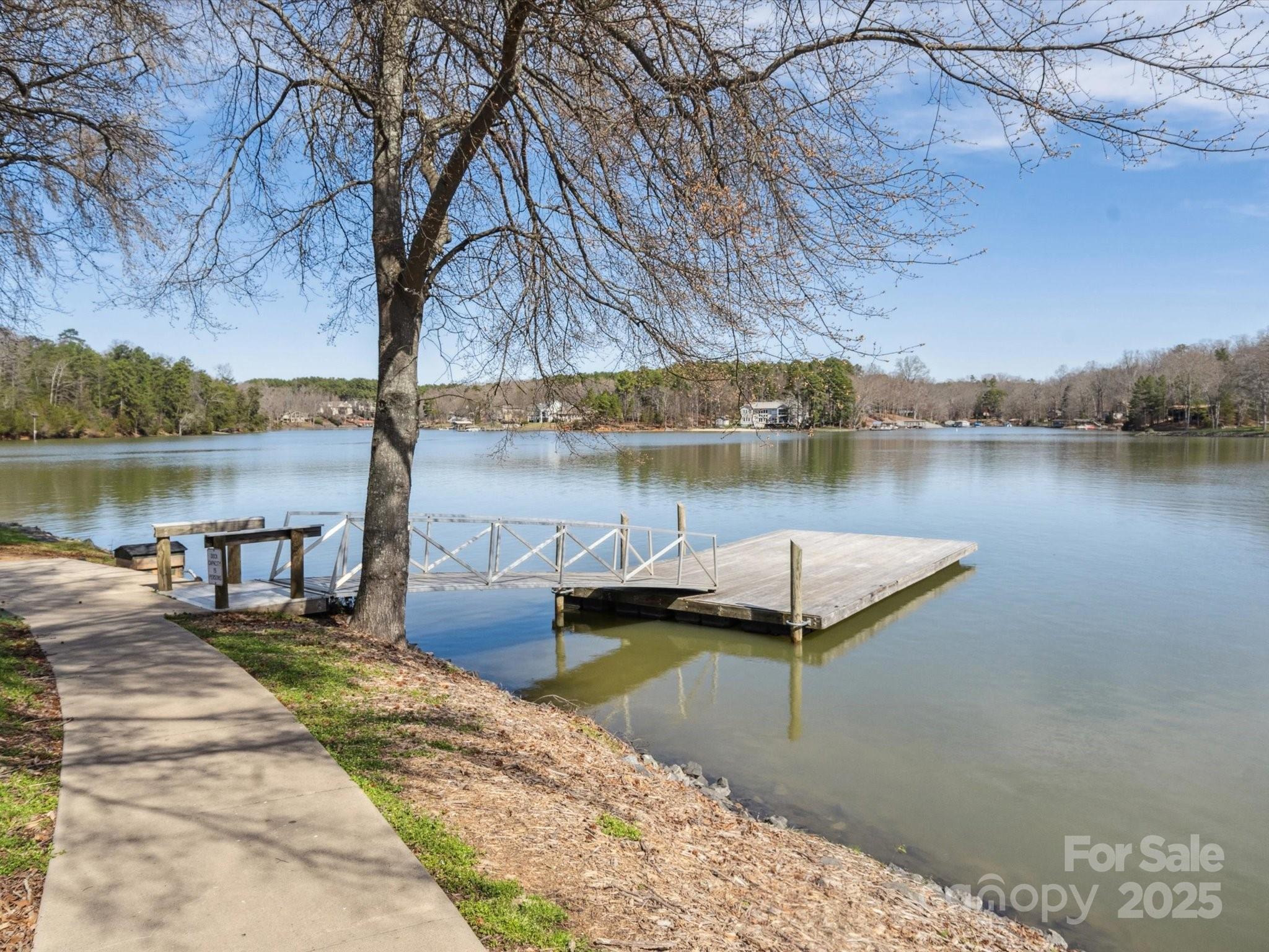 9111 Windjammer Drive Tega Cay, SC 29708 - Photo 35 of 36 a view of a lake with a bench under an umbrella