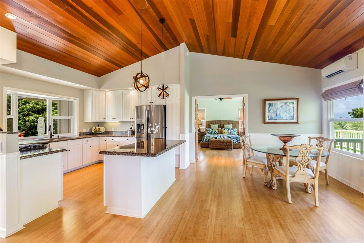 4321 Kapuna Road, Unit D Kilauea, HI 96754 - Photo 2 of 23 a very nice looking dining room with kitchen island wooden floor and a chandelier