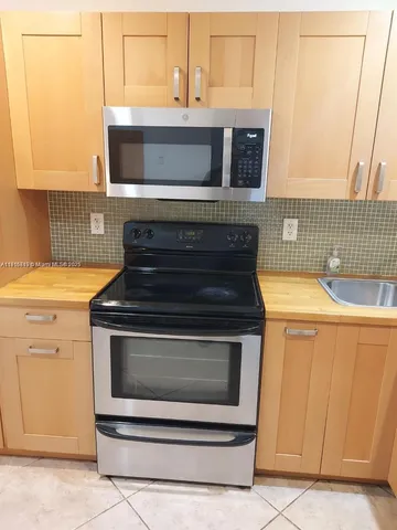 a stove top oven sitting inside of a kitchen