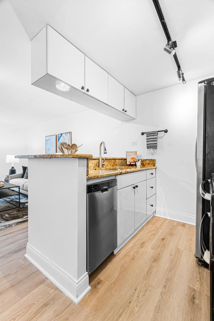 1221 North Dearborn Street, Unit PH8S Chicago, IL 60610 - Photo 5 of 24 a kitchen with a sink a refrigerator and cabinets