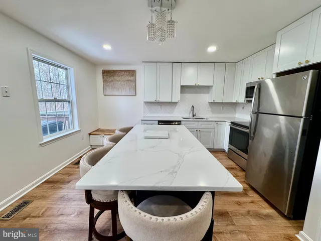 a kitchen with a table chairs a sink and refrigerator