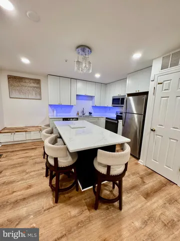 a kitchen with a dining table chairs and refrigerator
