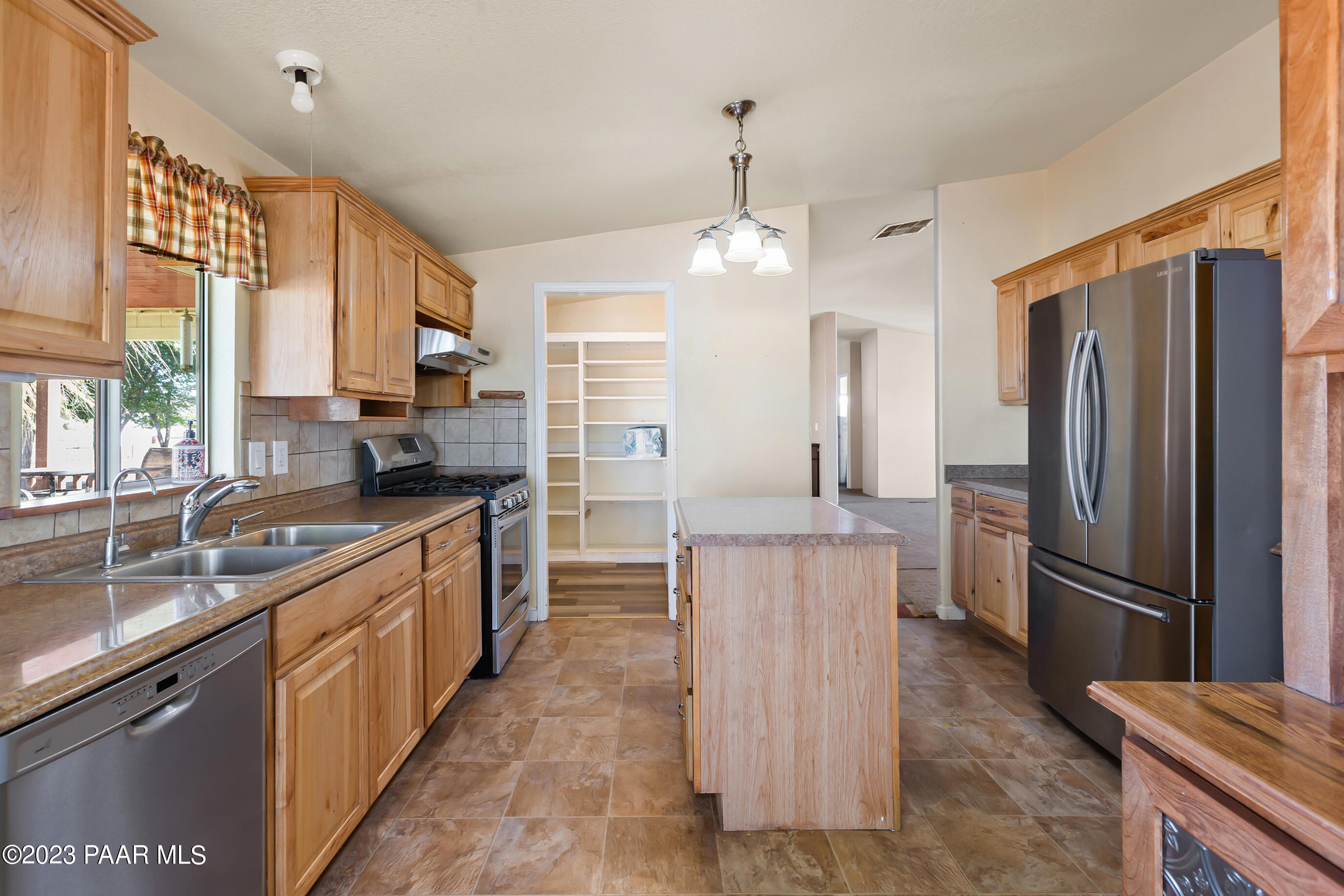 1240 Saddle Road Paulden, AZ 86334 - Photo 22 of 40 a kitchen with kitchen island granite countertop a refrigerator a sink dishwasher a stove and white cabinets with wooden floor