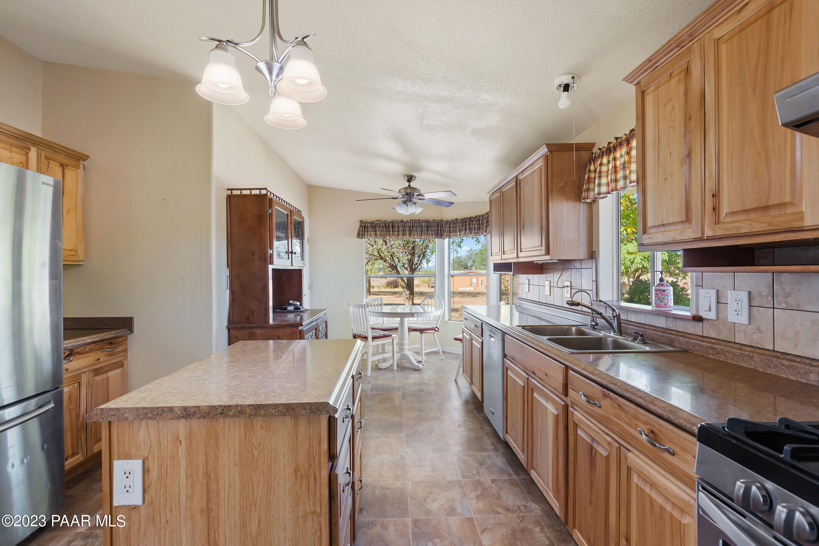 1240 Saddle Road Paulden, AZ 86334 - Photo 23 of 40 a kitchen with stainless steel appliances granite countertop a sink dishwasher stove and refrigerator with wooden floor