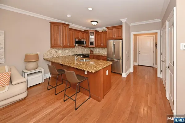 a kitchen with stainless steel appliances granite countertop a stove a sink and a refrigerator