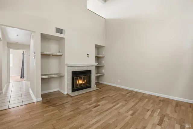 a view of empty room with wooden floor and fireplace
