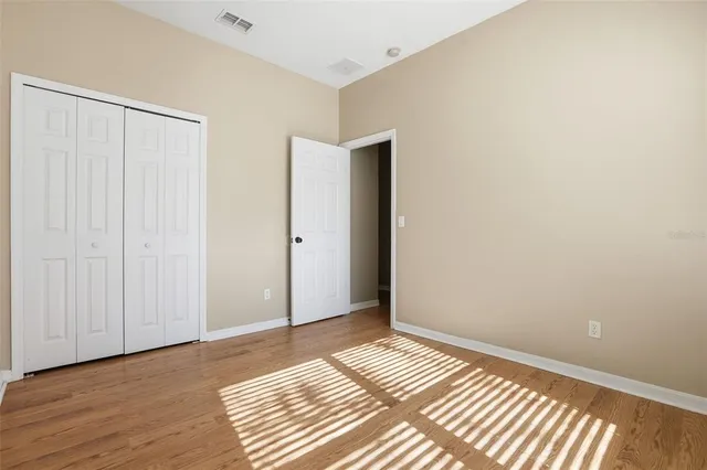 an empty room with a ceiling fan and windows