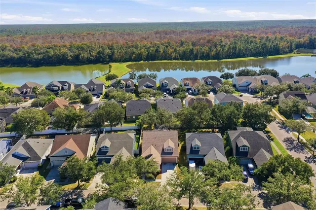 an aerial view of residential houses with outdoor space and trees