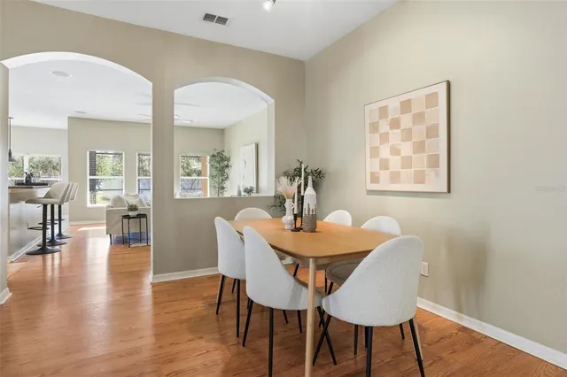 a living room with stainless steel appliances granite countertop furniture wooden floor and a view of kitchen